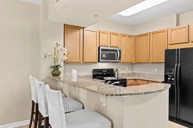 a kitchen with stainless steel appliances granite countertop a sink stove and microwave