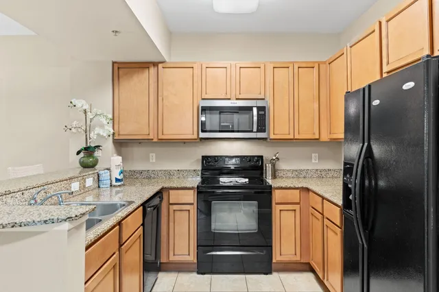 a kitchen with stainless steel appliances granite countertop a refrigerator and a sink