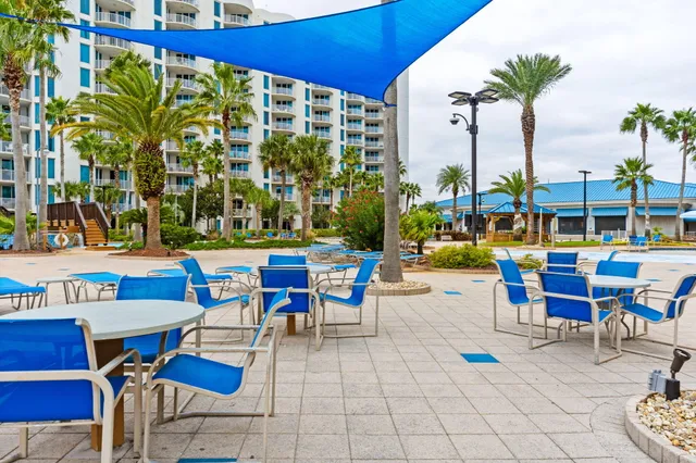 a living room with stainless steel appliances kitchen island granite countertop swimming pool and a large window