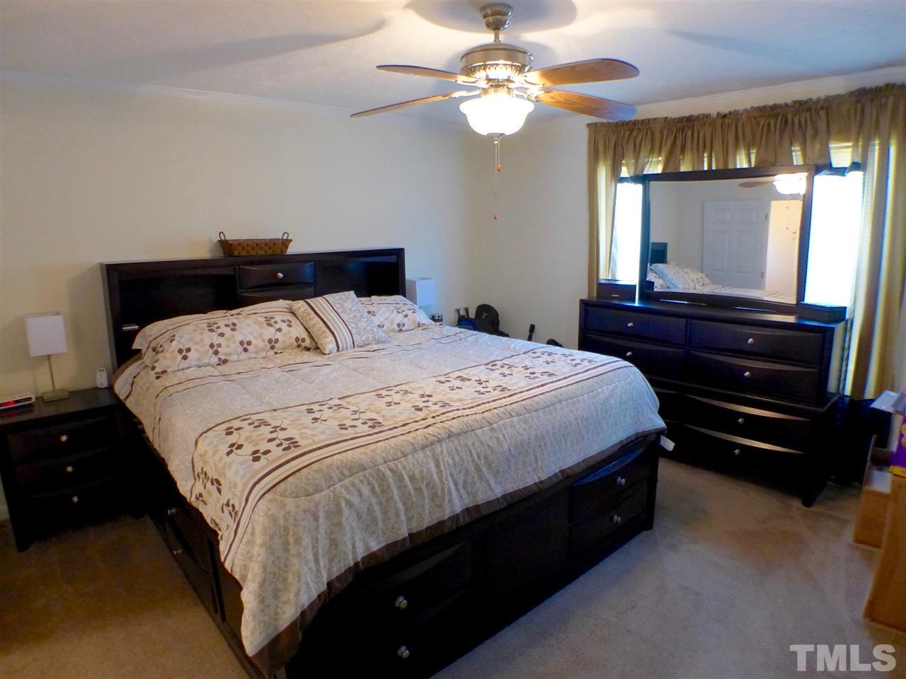 1955 Holly Grove Road Benson, NC 27504 - Photo 13 of 25 a bedroom with a bed and a chandelier