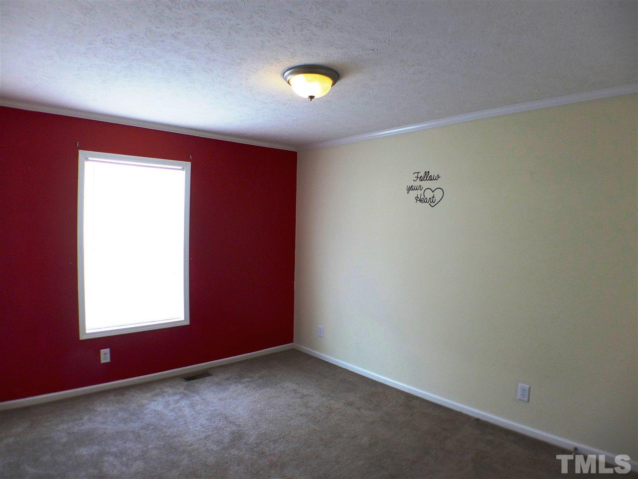 1955 Holly Grove Road Benson, NC 27504 - Photo 18 of 25 an empty room with a window and a fan