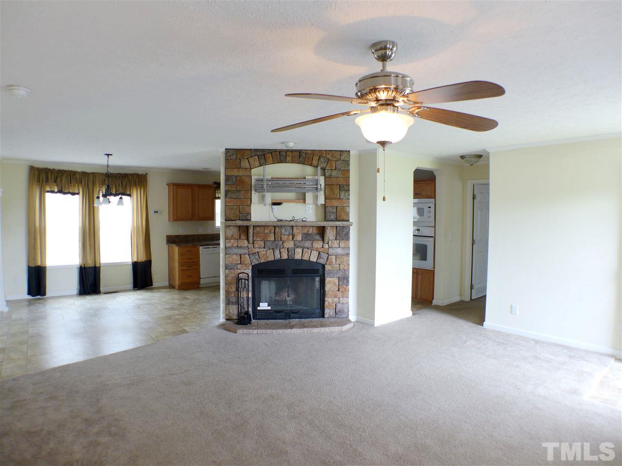 1955 Holly Grove Road Benson, NC 27504 - Photo 3 of 25 a view of a livingroom with a ceiling fan a fireplace and a window