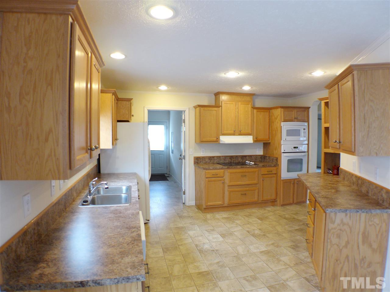 1955 Holly Grove Road Benson, NC 27504 - Photo 7 of 25 a large kitchen with a large counter top appliances and cabinets