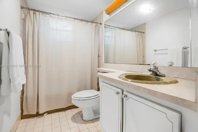 a bathroom with a sink a toilet a mirror and shower