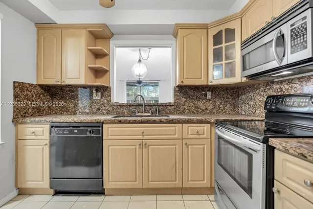 a kitchen with cabinets appliances and a sink