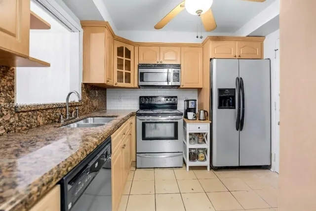a kitchen with stainless steel appliances granite countertop a refrigerator and a stove