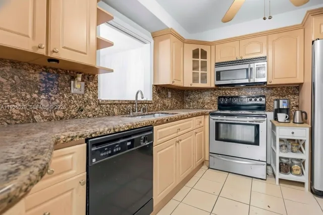 a kitchen with granite countertop a stove top oven microwave and cabinets