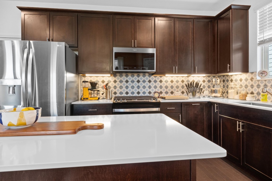 a kitchen with stainless steel appliances wooden cabinets and a counter top space