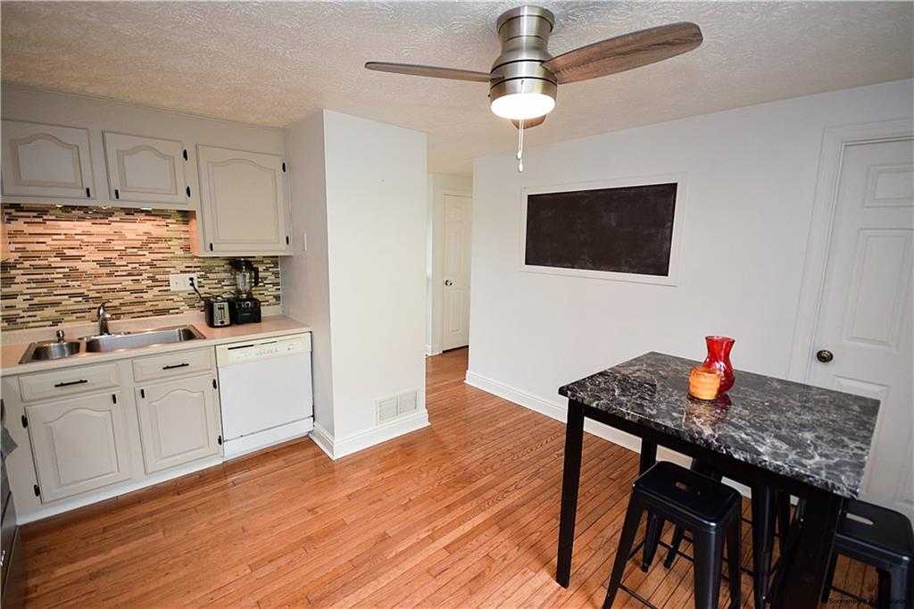 508 Countryside Drive McKees Rocks, PA 15136 - Photo 7 of 25 a kitchen with stainless steel appliances granite countertop a stove a refrigerator a microwave a dining table and chairs with wooden floor