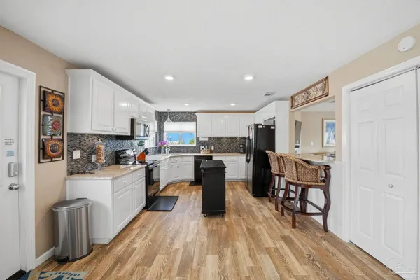 a kitchen with a sink a counter top space stainless steel appliances and cabinets