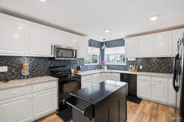 a kitchen with a sink stove top oven and microwave