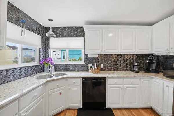 a kitchen with granite countertop a sink stainless steel appliances and cabinets