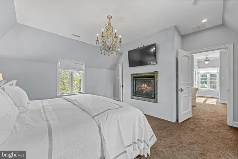 a bedroom with a bed couch and windows