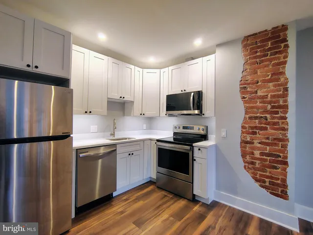 a kitchen with stainless steel appliances a refrigerator sink and microwave