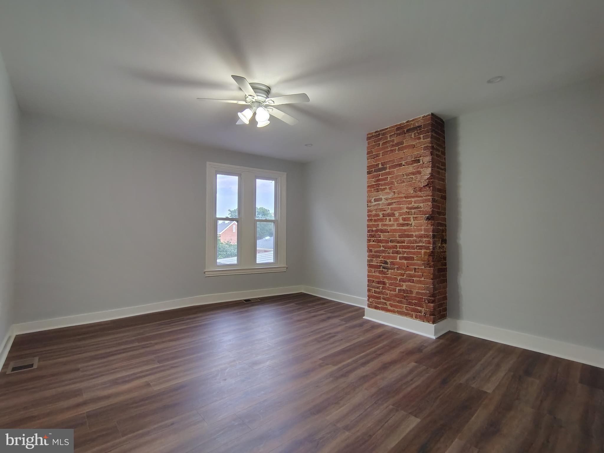 230 South Market Street, Unit 3 Frederick, MD 21701 - Photo 5 of 16 a view of an empty room with wooden floor and a window