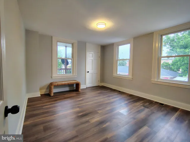 a view of a room with wooden floor and windows