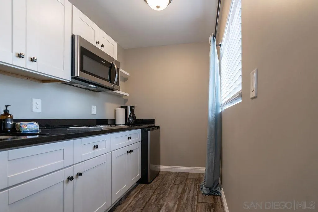 841 Beryl Street, Unit A San Diego, CA 92109 - Photo 11 of 22 a kitchen with stainless steel appliances granite countertop a sink and a microwave