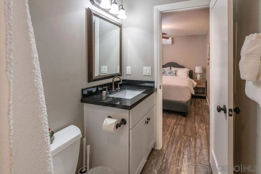 841 Beryl Street, Unit A San Diego, CA 92109 - Photo 14 of 22 a bathroom with a granite countertop sink toilet and shower a mirror