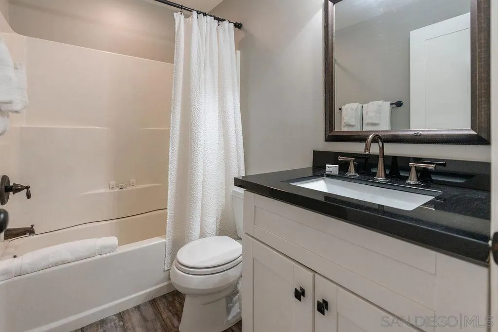 841 Beryl Street, Unit A San Diego, CA 92109 - Photo 4 of 22 a bathroom with a granite countertop sink toilet and shower