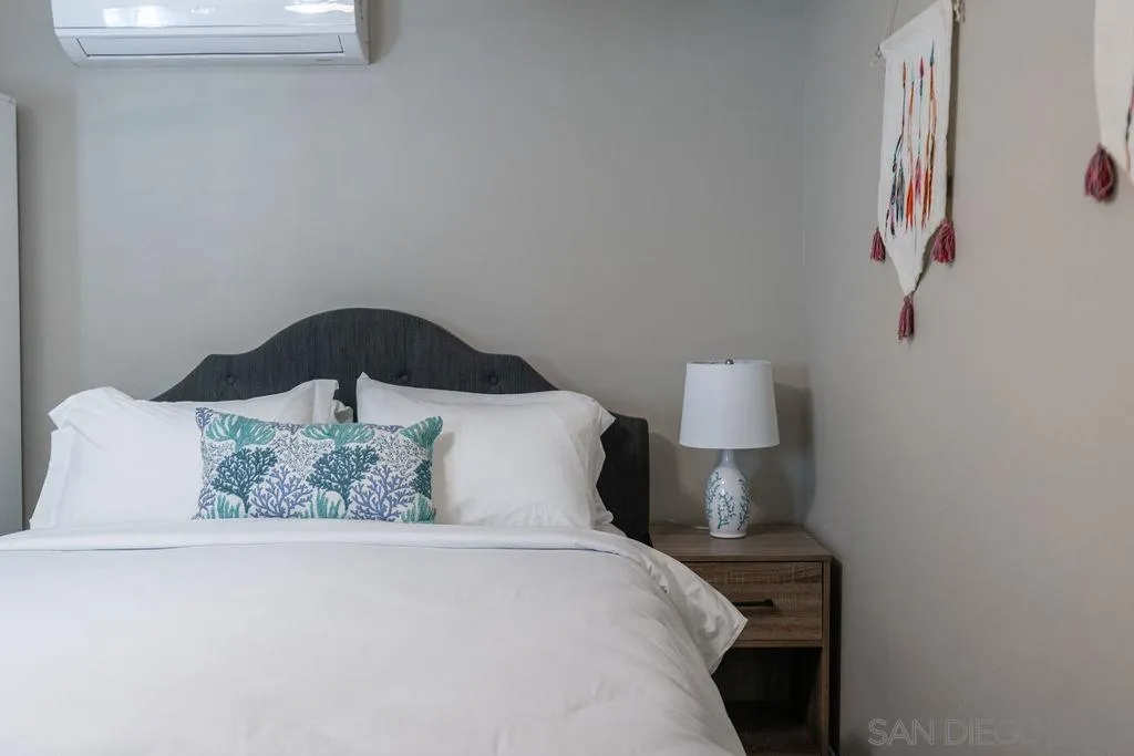 841 Beryl Street, Unit A San Diego, CA 92109 - Photo 8 of 22 a bedroom with a bed and a lamp on dresser