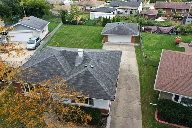 an aerial view of a house with garden space and street view