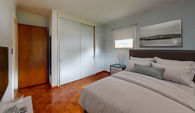 a bedroom with a bed and a painting on the wall