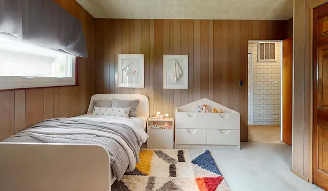 a bedroom with a bed and a painting on the wall