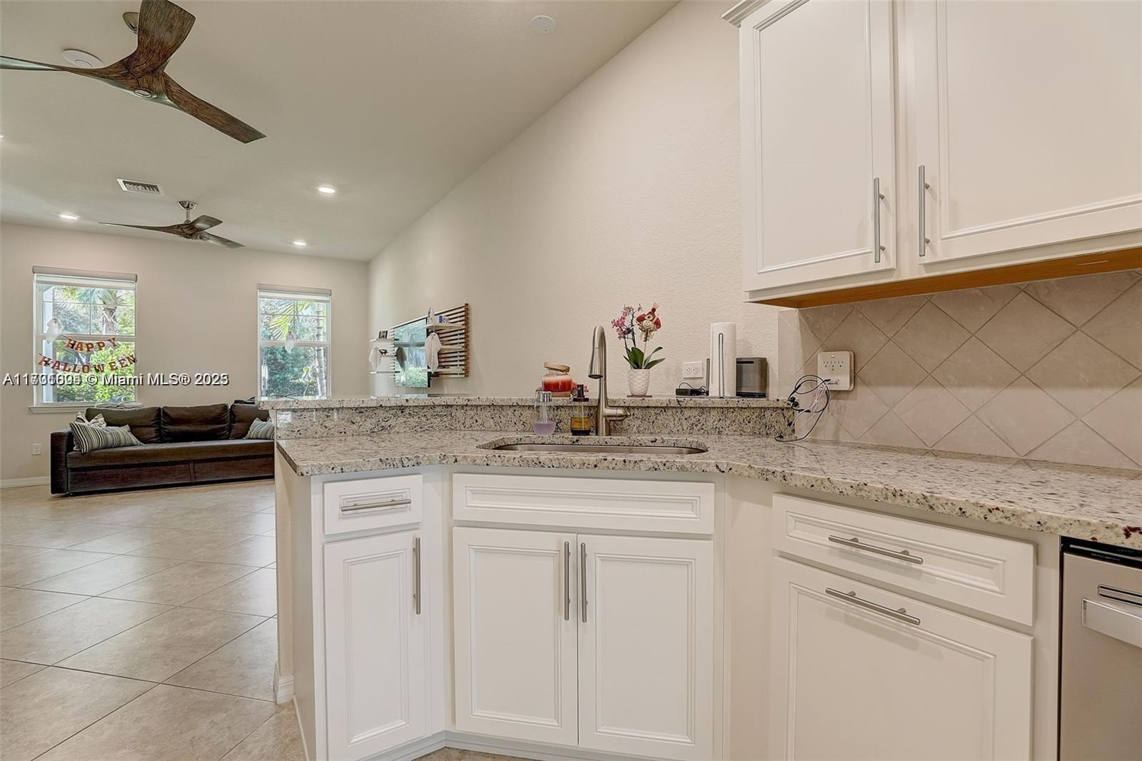 5182 Eucalyptus Drive, Unit 4 Hollywood, FL 33021 - Photo 9 of 22 a kitchen with granite countertop white cabinets and white appliances