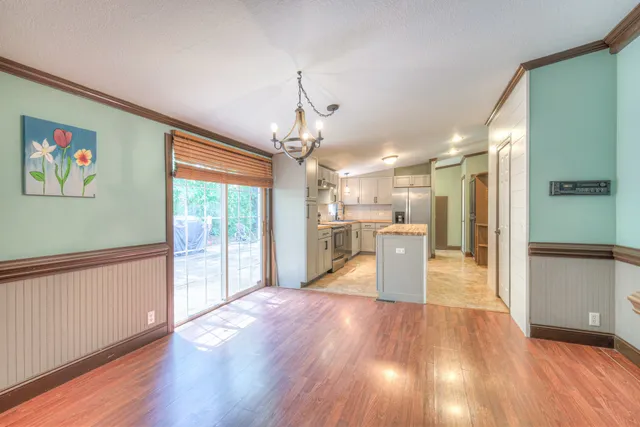 a view of a kitchen with wooden floor and a window