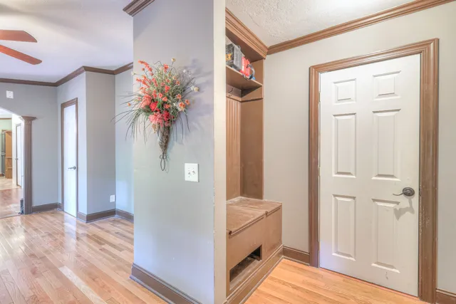 a view of hallway with wooden floor and cabinet