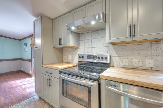 a kitchen with granite countertop a stove a sink and a microwave