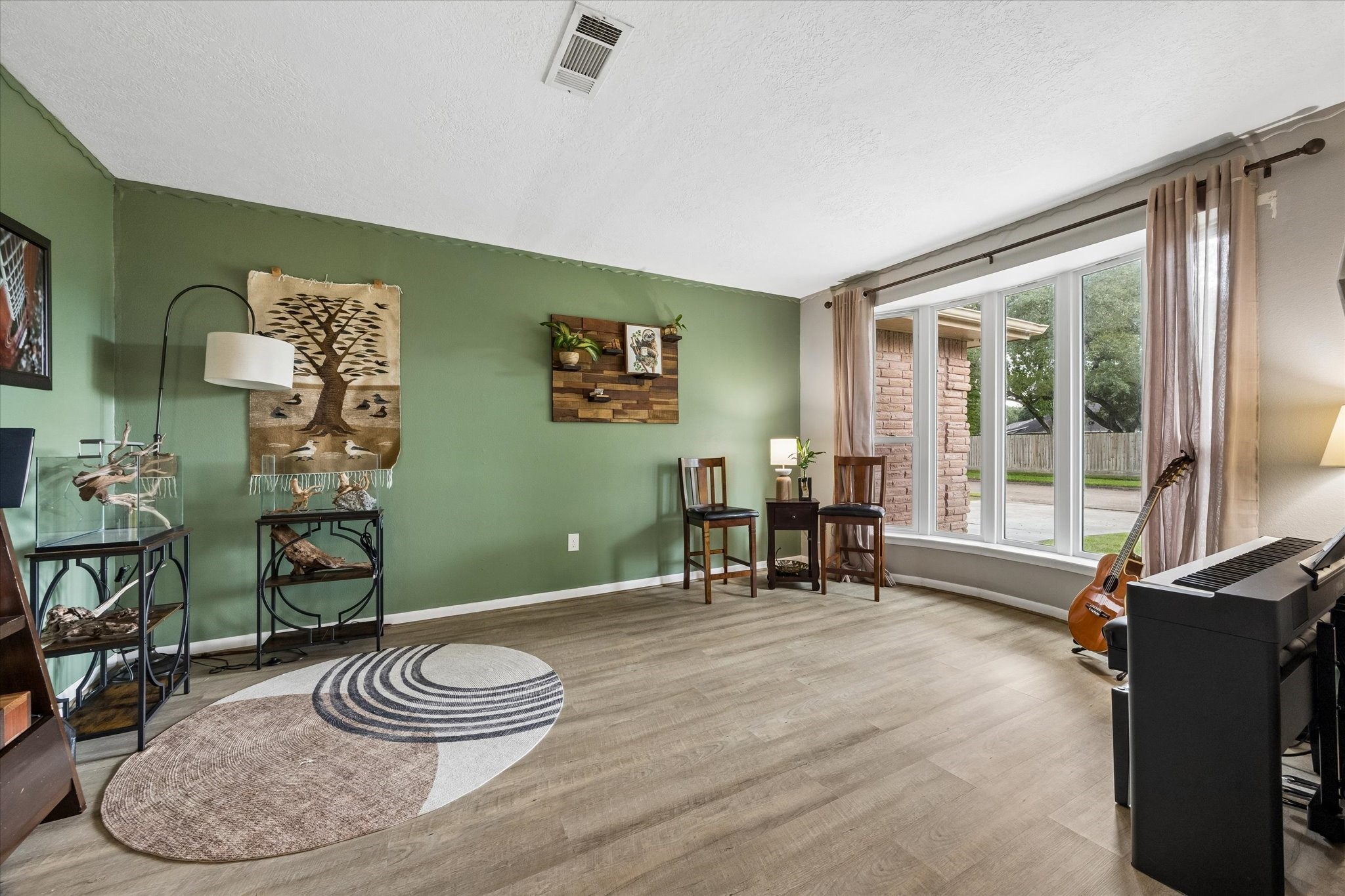 1931 Westlake Road Houston, TX 77062 - Photo 9 of 28 Just off the entry, this flexible space is ready to work your way as a study, formal living or dining room. LVP flooring, decorator paint and a full wall of floor to ceiling windows fill the space with natural light and offer picture perfect front yard views.