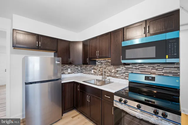 a kitchen with stainless steel appliances and wood cabinets