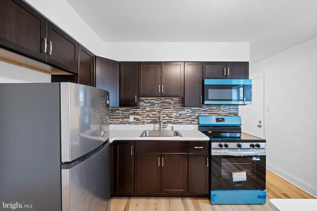 a kitchen with stainless steel appliances a sink stove and refrigerator