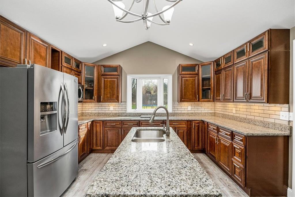 720 Conway Wallrose Road Freedom, PA 15042 - Photo 8 of 25 a kitchen with stainless steel appliances granite countertop a refrigerator a sink dishwasher a stove with wooden cabinets and floor