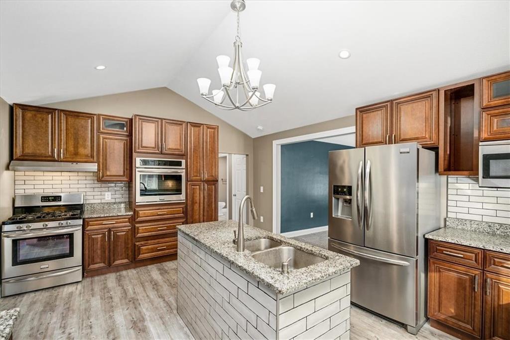 720 Conway Wallrose Road Freedom, PA 15042 - Photo 9 of 25 a kitchen with stainless steel appliances granite countertop a refrigerator a stove oven a sink dishwasher and wooden cabinets with wooden floor