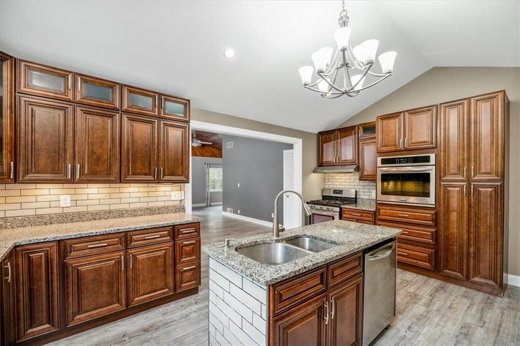 720 Conway Wallrose Road Freedom, PA 15042 - Photo 10 of 25 a kitchen with stainless steel appliances granite countertop a sink dishwasher stove and refrigerator with wooden floor