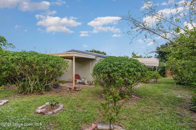a backyard of a house with table and chairs