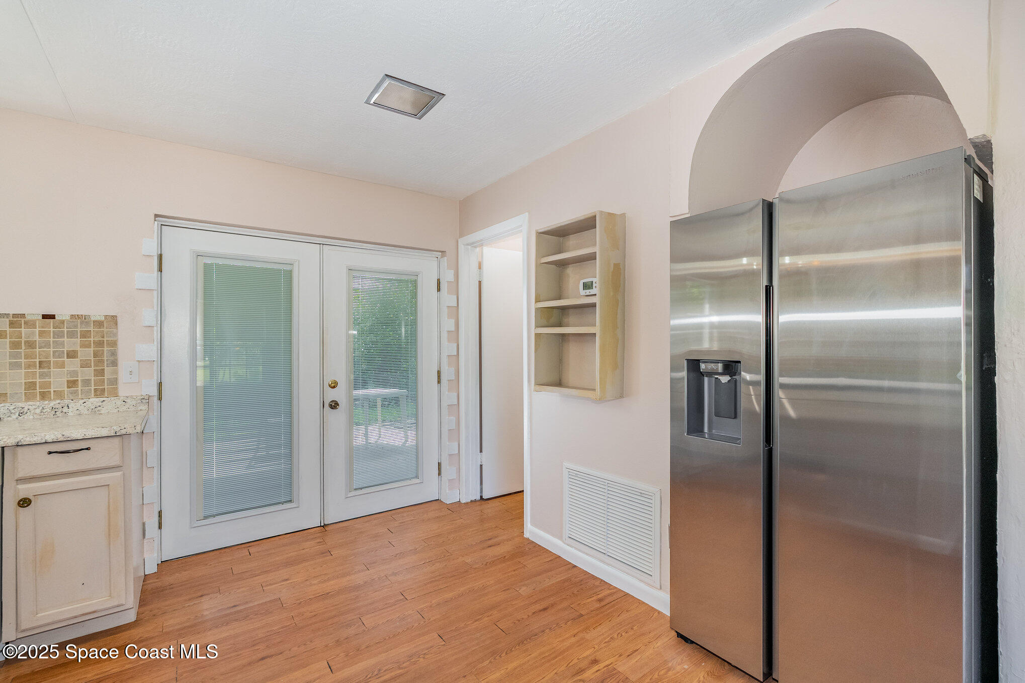 961 Kaufman Street Cocoa, FL 32927 - Photo 6 of 15 a view of a refrigerator in kitchen and a glass door