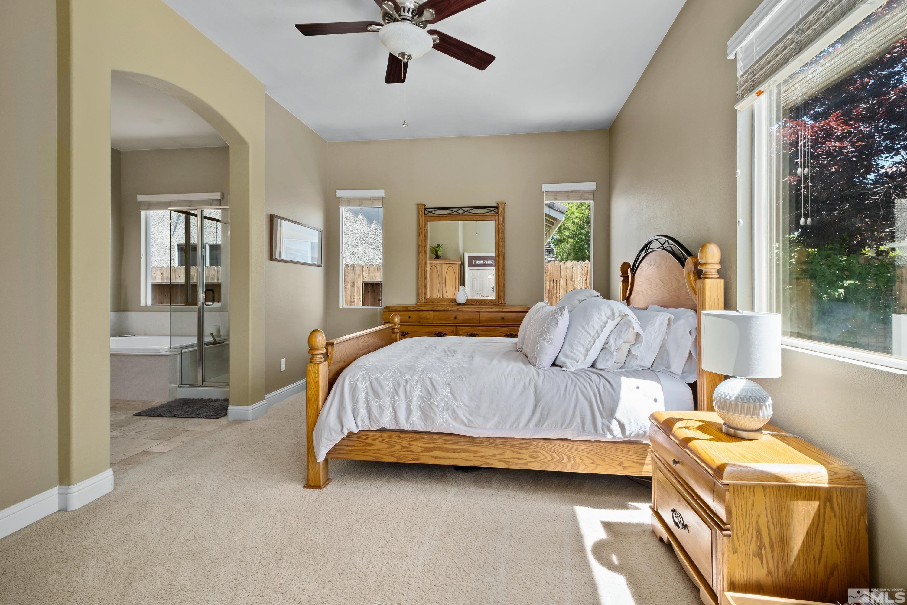 1600 Red Gulch Court Reno, NV 89521 - Photo 26 of 39 a spacious bedroom with a bed and a chandelier