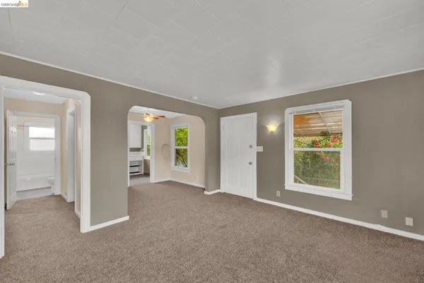 an empty room with windows and closet