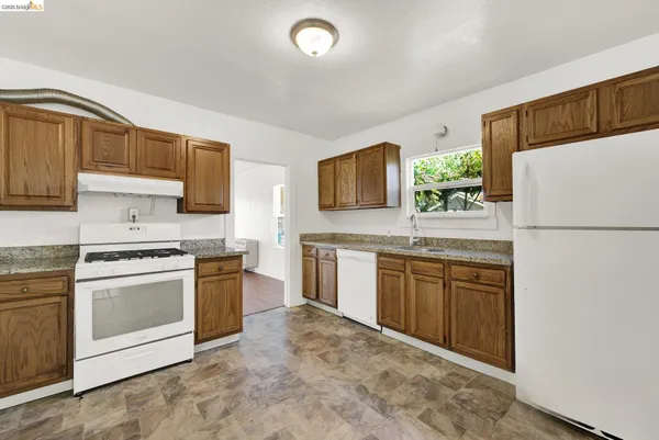 a kitchen with stainless steel appliances granite countertop a stove a sink and a refrigerator