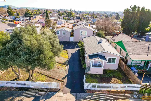 an aerial view of residential houses with outdoor space and trees