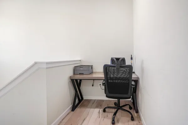 a view of a workspace with furniture and wooden floor