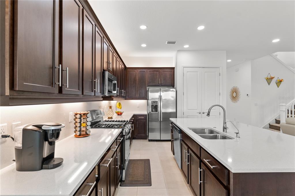 32558 Tree Of Life Avenue Wesley Chapel, FL 33543 - Photo 11 of 73 a kitchen with granite countertop a sink a stove and cabinets