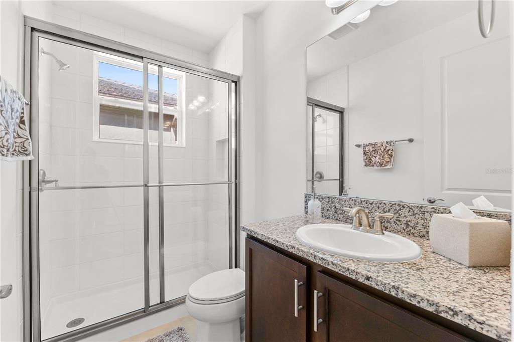 32558 Tree Of Life Avenue Wesley Chapel, FL 33543 - Photo 34 of 73 a bathroom with a granite countertop sink toilet and shower
