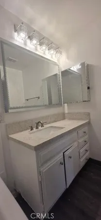 a view of a room with wooden floor and mirror