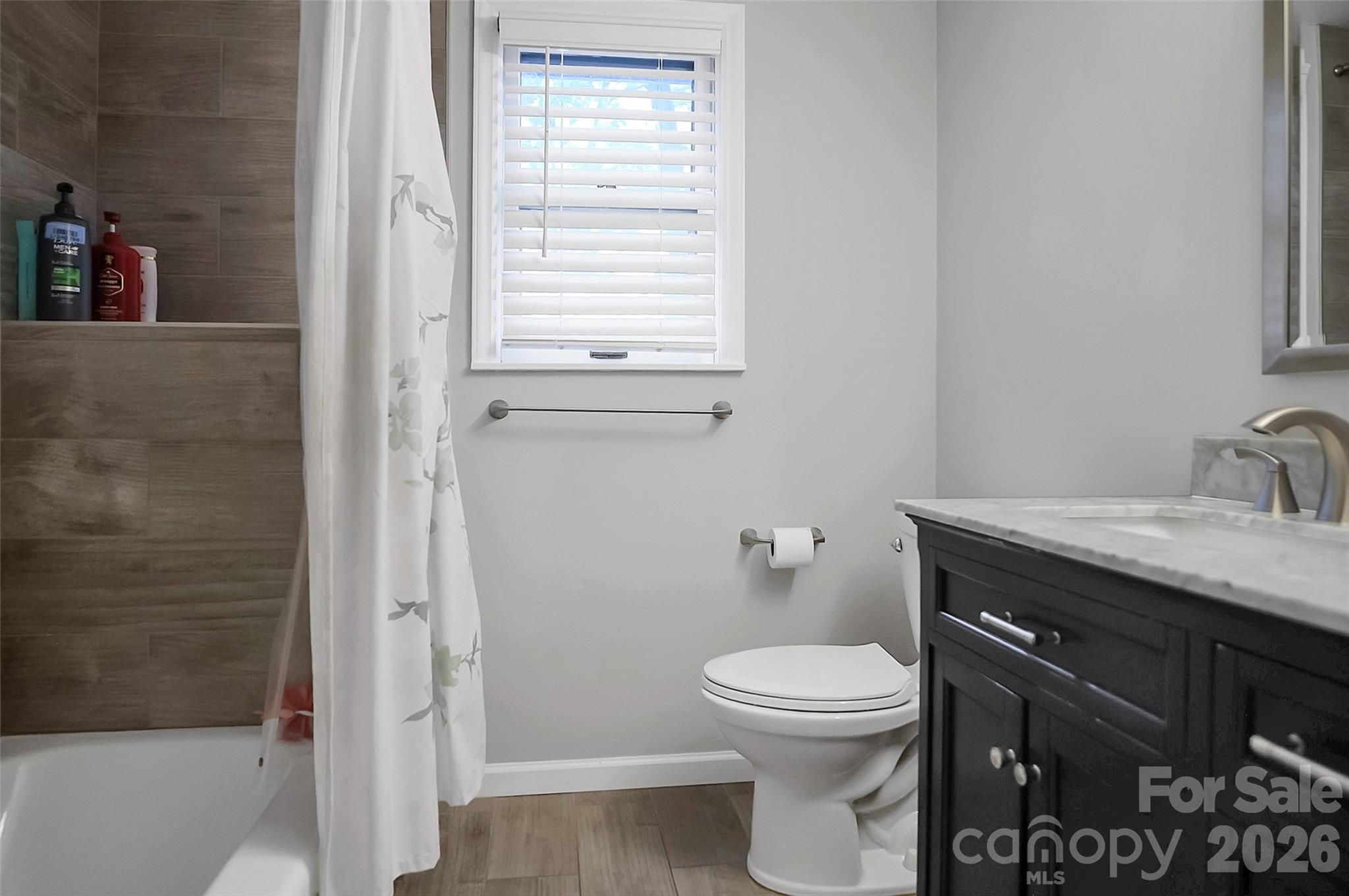808 Old Mt Holly Road Stanley, NC 28164 - Photo 38 of 48 a bathroom with a granite countertop toilet a sink a mirror and a window