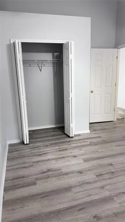 an empty room with wooden floor and closet