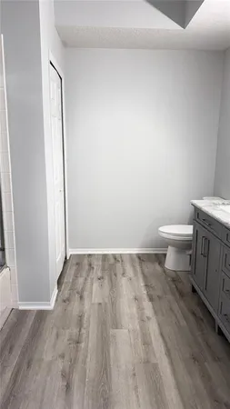 a bathroom with a toilet and a wooden floor
